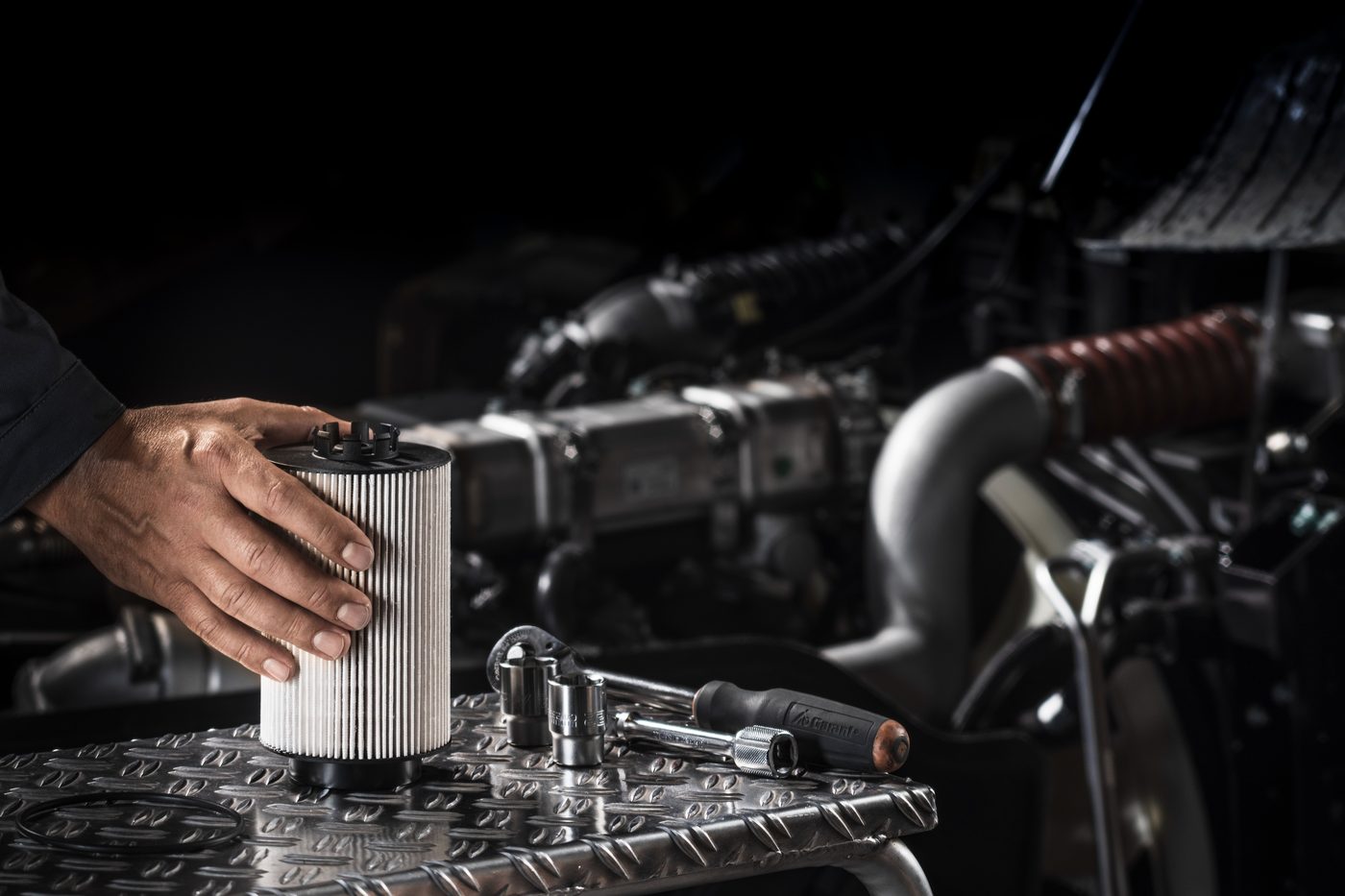 Technician fitting a genuine MAN fuel filter in the workshop